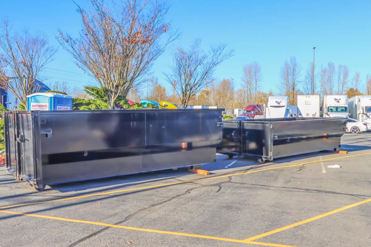 Professional dumpster rental service with roll-off container on residential driveway in West St. Paul